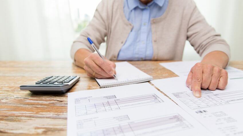 Watch out for annuities in your 401k. hands writing notes from tax documents