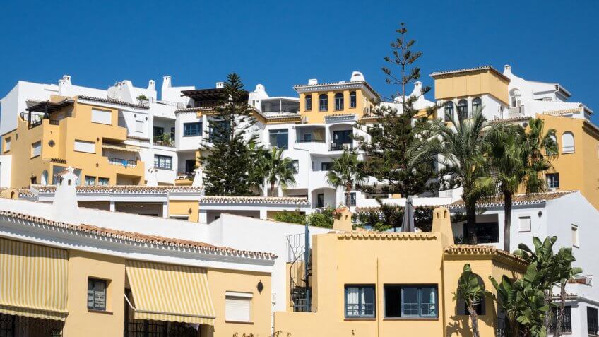 Don't fall for high homeowners association fees and timeshare scams. yellow and white apartments with trees