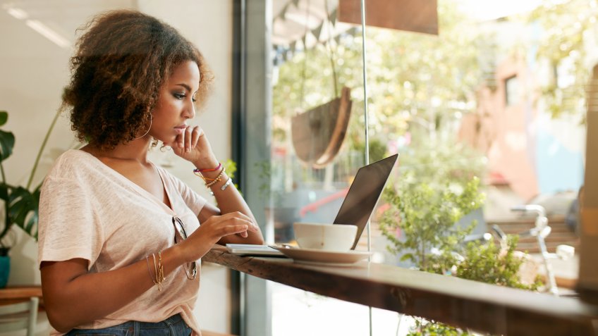 Young female at cafe using laptop.