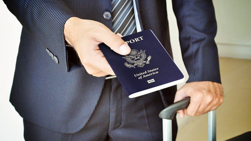 Man in suit handing over passport Man in suit handing over passport