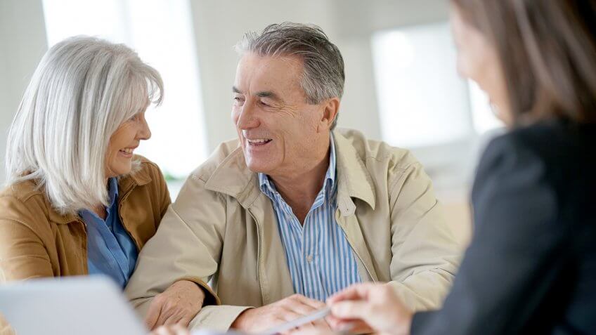 old senior retired couple talking to an adviser