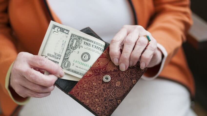 woman removing $6 from her purse