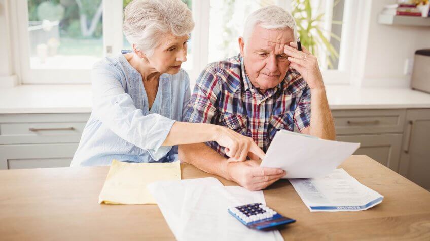 elderly couple looking over bills