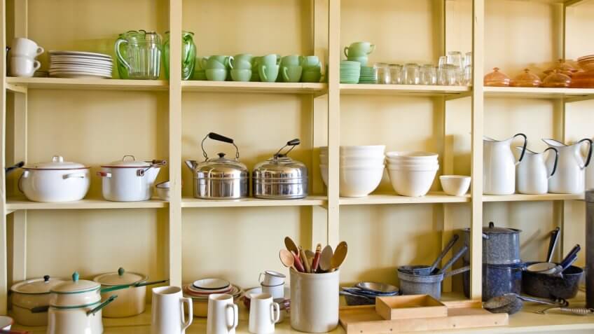 kitchen shelves with various pots, cups, plates and other kitchen items