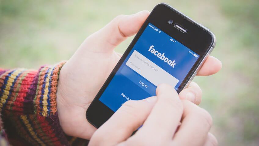 Person using Facebook on their phone Person using Facebook on their phone