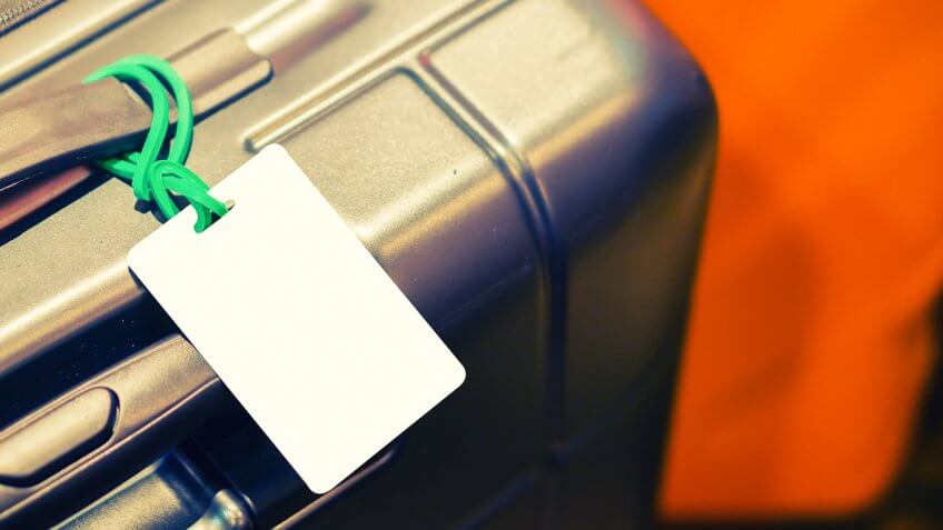 White luggage tag attached to suitcase White luggage tag attached to suitcase
