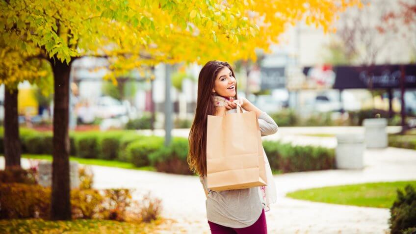 young women walking down a street carrying shopping bags young women walking down a street carrying shopping bags