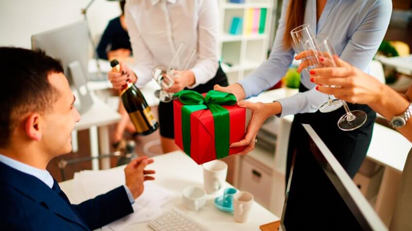 Businesswoman giving gift box to colleague