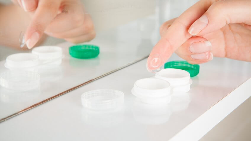 Female hands holding contact lens