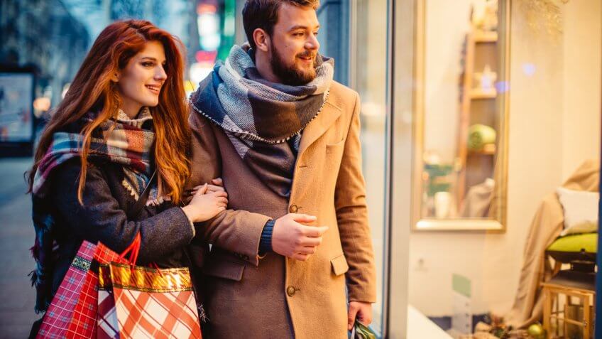 Couple window shopping outdoors in winter city street. Couple window shopping outdoors in winter city street.
