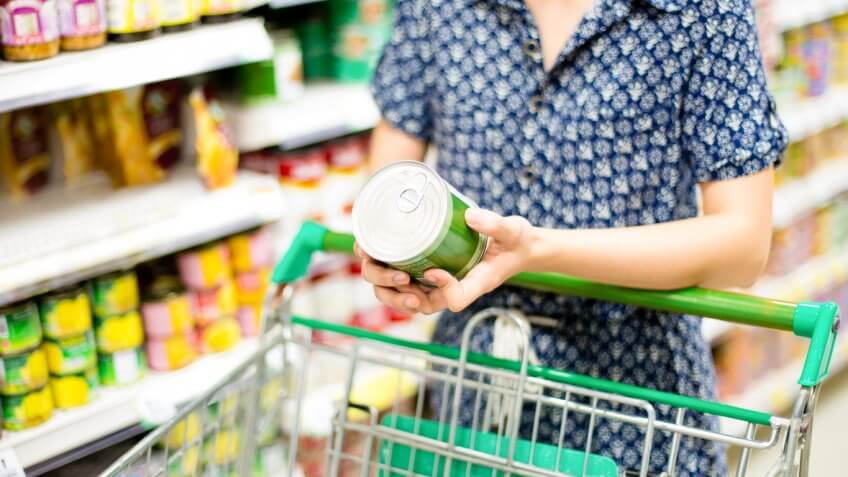 woman looking at canned good