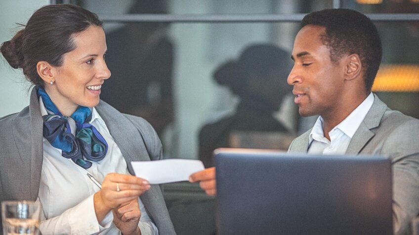Young businesswoman and man working together on a laptop, and having a business conversation in a modern office space.