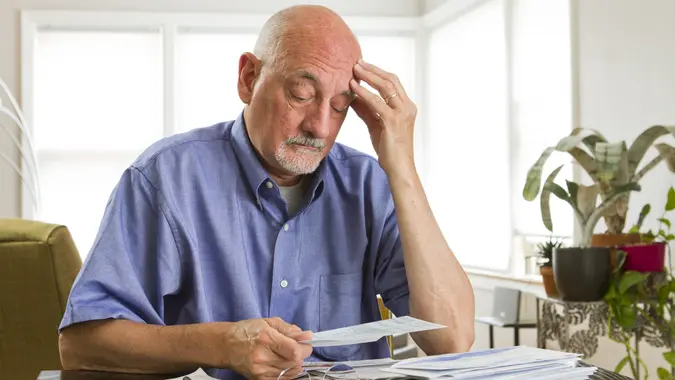 Older man paying bills.