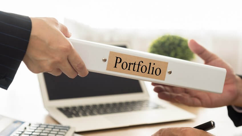 man handing portfolio binder to another man