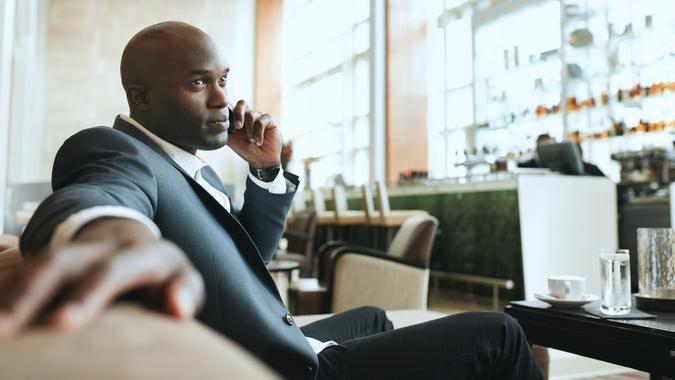 10 Best and Worst Industries for Work-Life Balance, African business man talking on mobile phone while waiting in a 