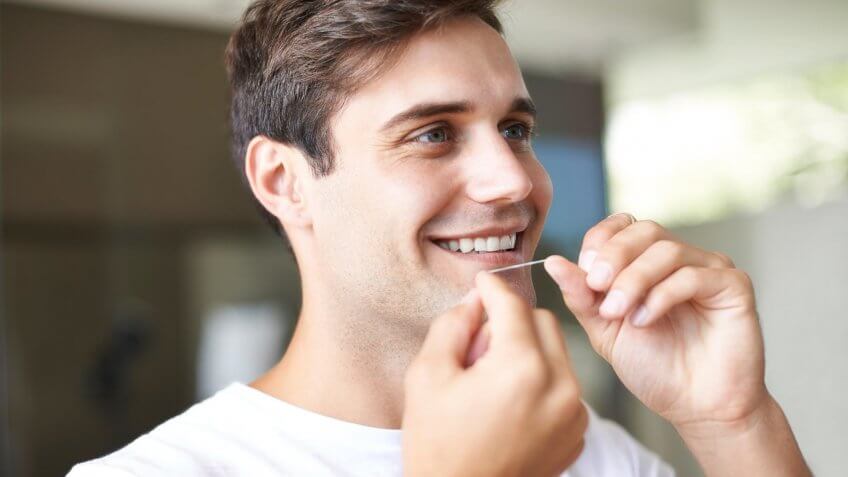 man flossing his teeth
