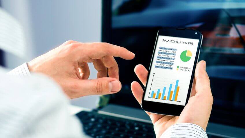 Businessman checks the financial analysis on smartphone.