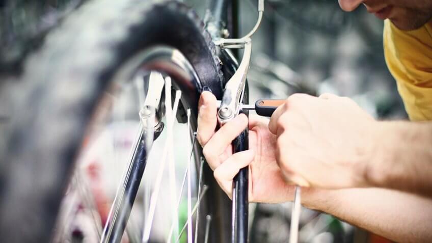 person fixing bike brakes