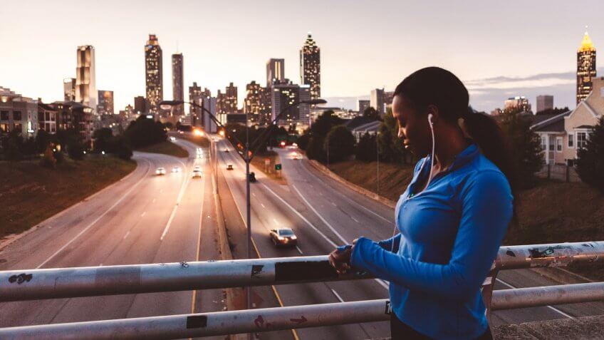 Young women running fast through the city at night.