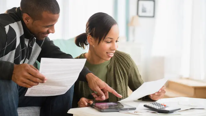 Couple paying bills in living room.