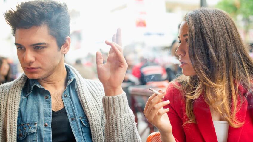 woman smoking with annoyed man