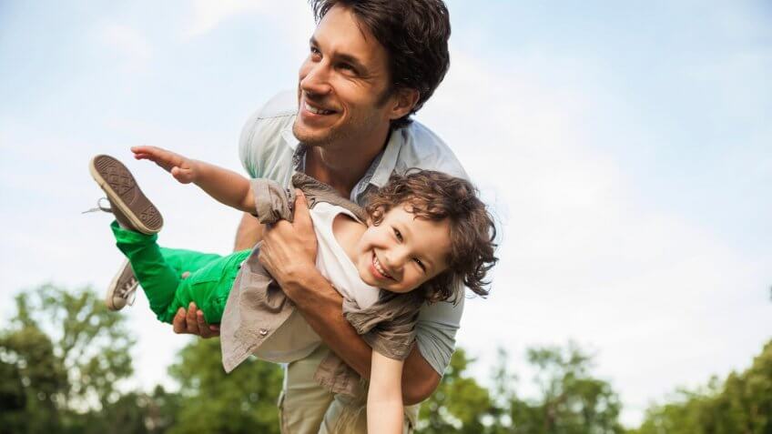 father and kid playing in park
