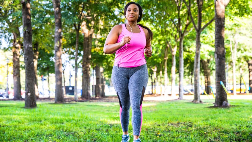 Plus size women jogging and exercising at the park and walking outdoor in the city streets in Chicago, United States - USA.