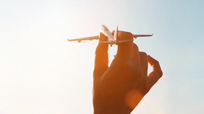 hand playing with miniature airplane