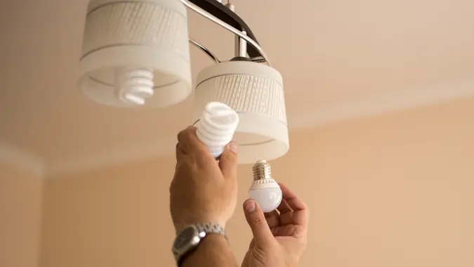 Image of a hand putting energy efficient lightbulbs into a socket.