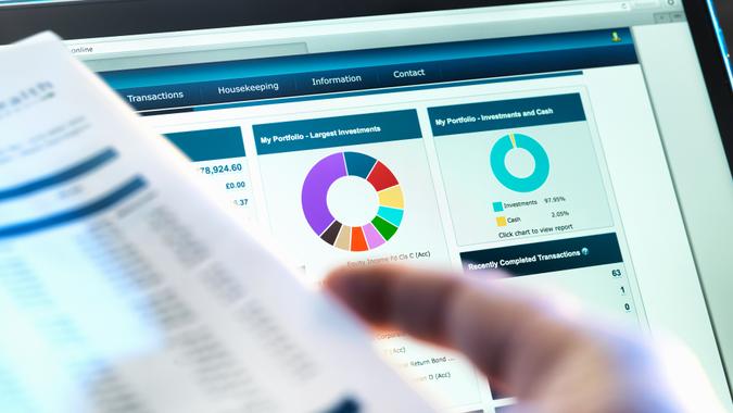 Rebalance Your Portfolio Investor checking performance of financial portfolio online whilst reviewing investment statement.