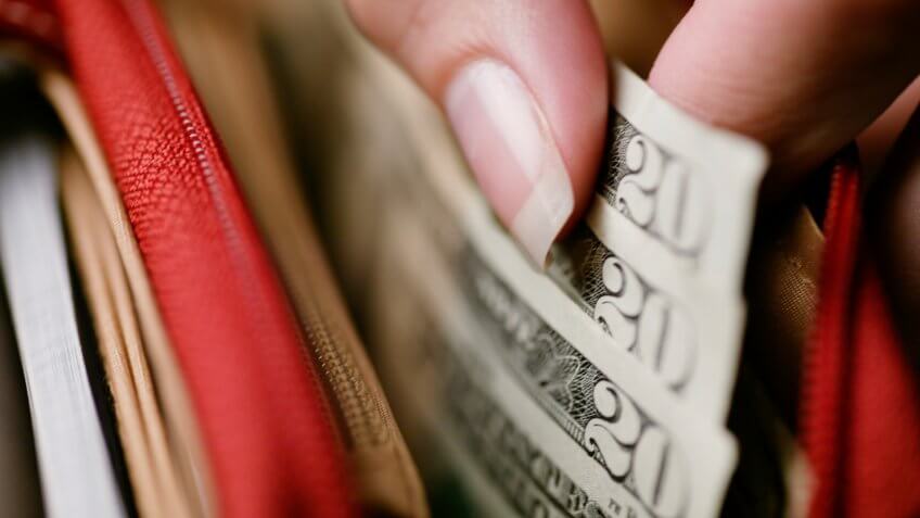 Woman's hand taking money out of wallet.