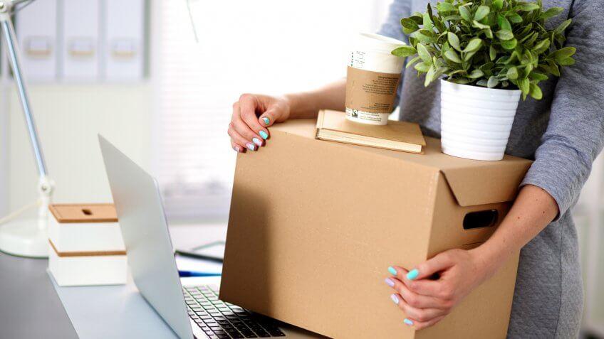 close up of woman holding storage box and laptop