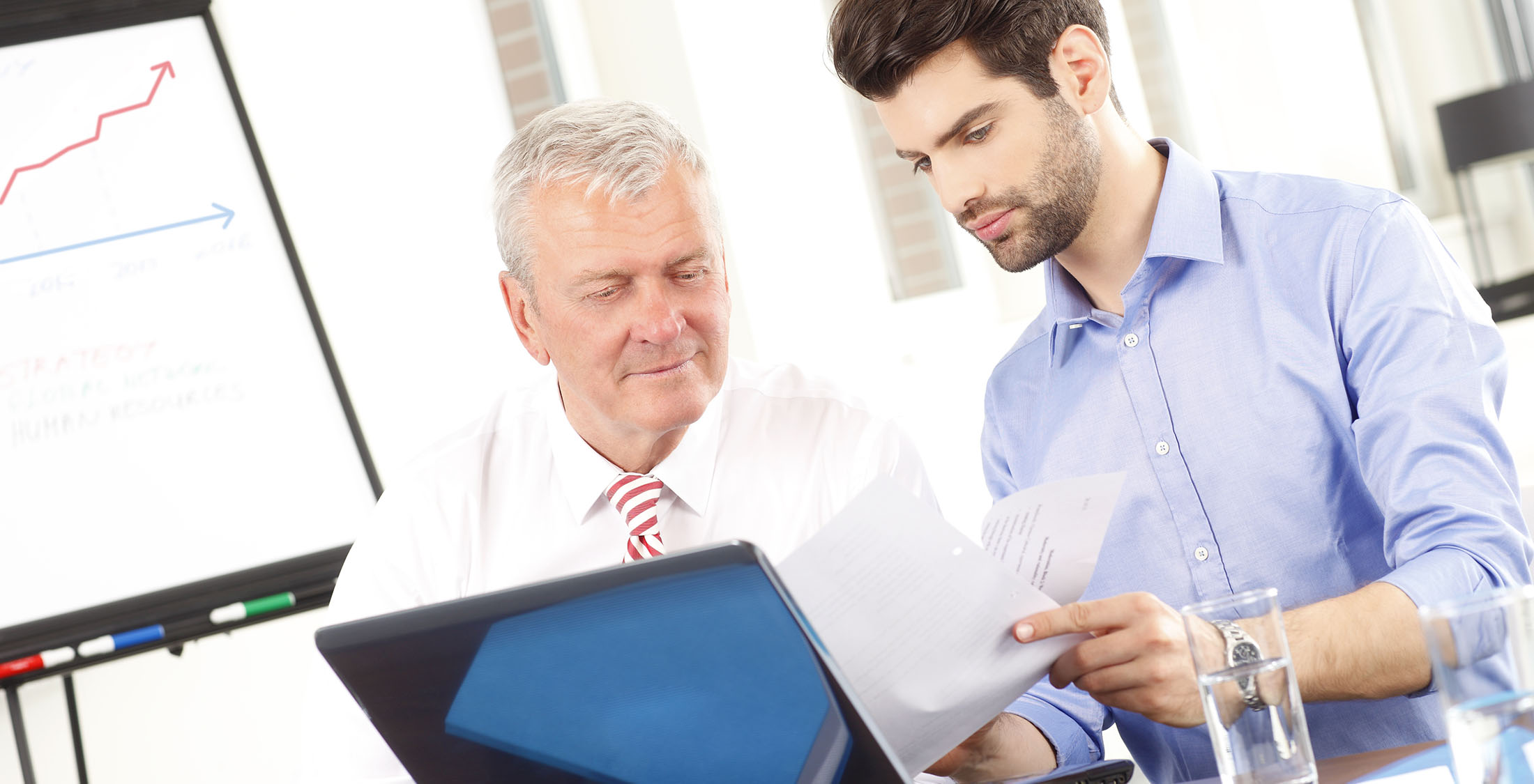 Invest in individual stocks two businessmen looking at paperwork