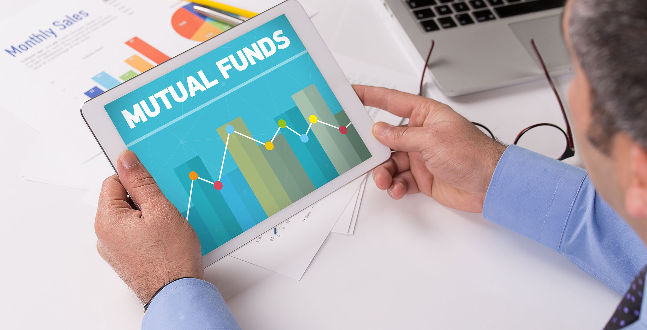 Pick mutual funds man looking at mutual funds on tablet