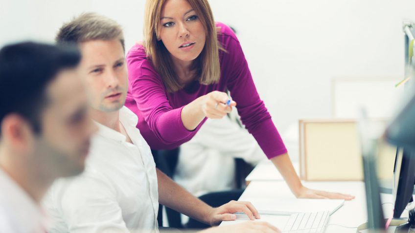 young woman instructing employees