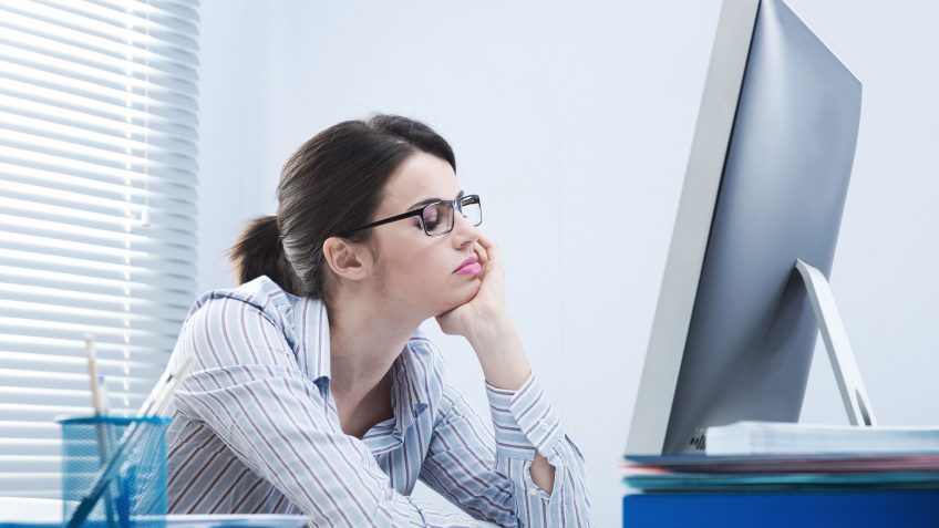 frustrated young woman looking at a computer monitor