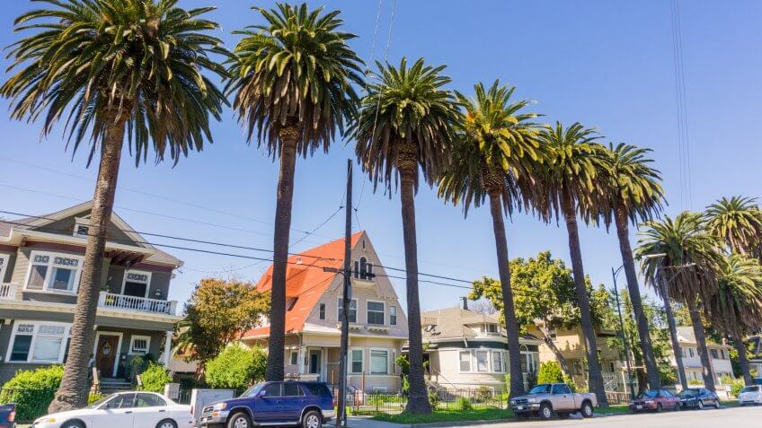 Old houses and palm trees on a street in downtown San Jose, california
