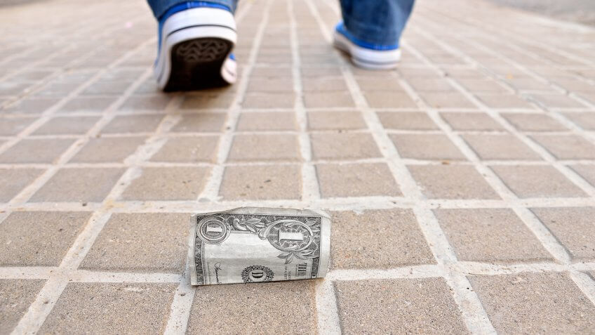 $1 on the floor with someone walking away
