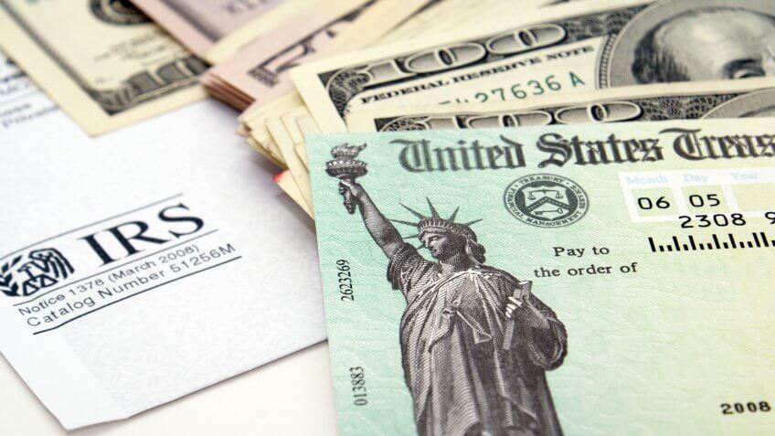 Stimulus economic tax return check and USA currency.