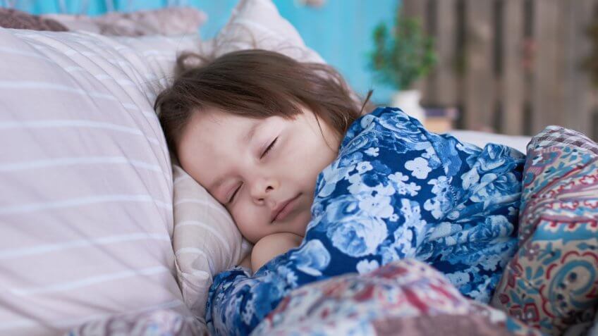 small child sleeping on a bed