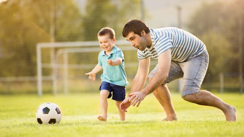 father and toddler playing on soccer field father and toddler playing on soccer field