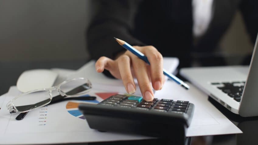 close up of person using a calculator close up of person using a calculator
