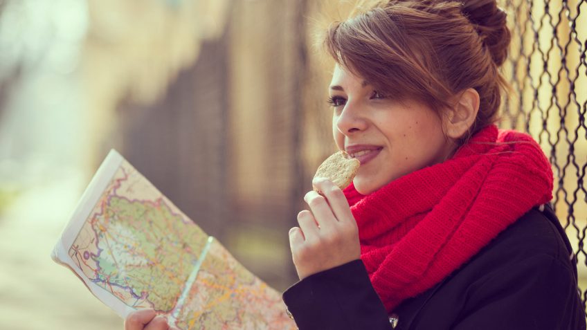 woman holding a map and eating a cookie