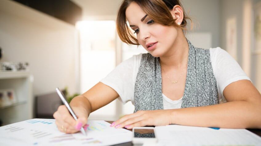 young woman filling out paperwork at home young woman filling out paperwork at home