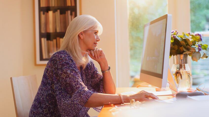 Senior woman working at computer in home office