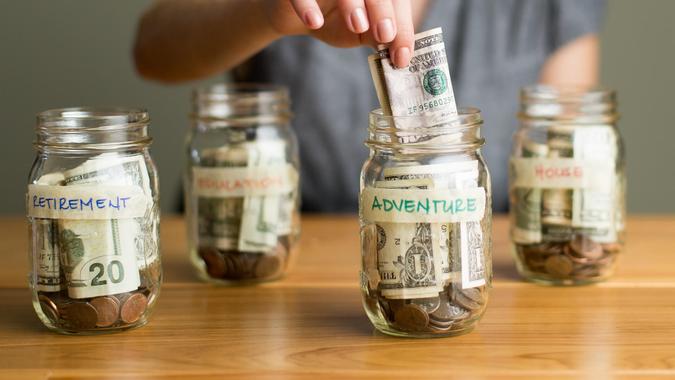 A happy woman saving in jars.