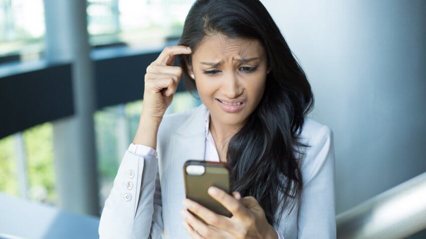 woman looking frustrated at her phone