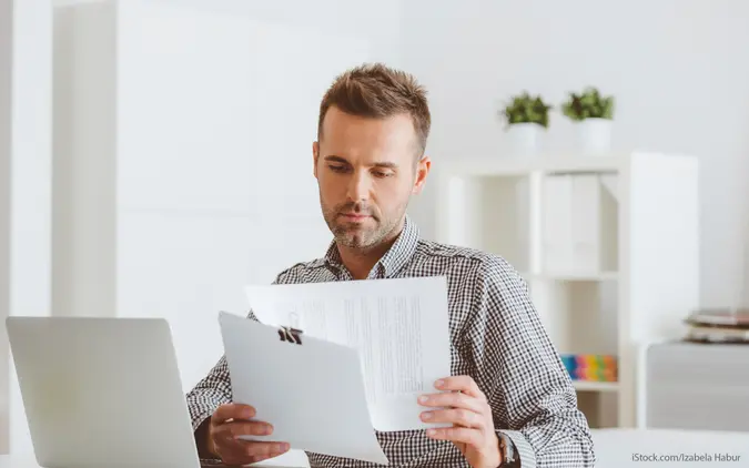 man reviewing paperwork and thinking about different insurance coverage