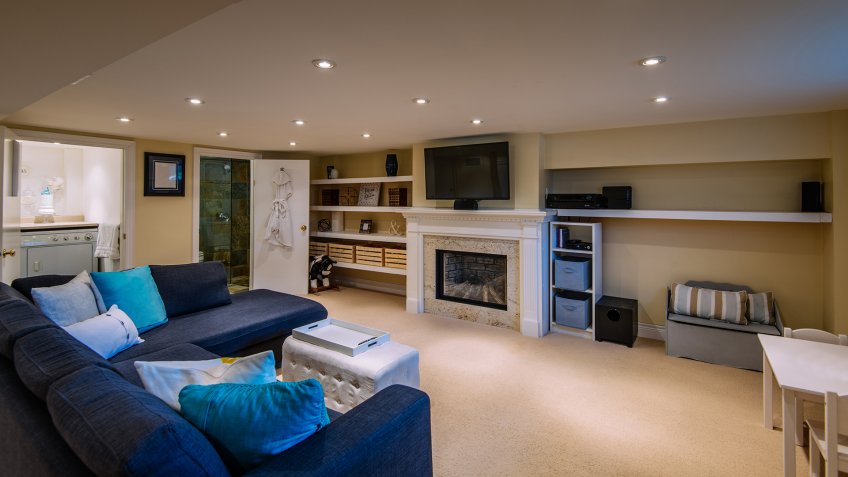 Interior of modern renovated lover floor basement common room with addition of bathroom and laundry room, in private city residence.