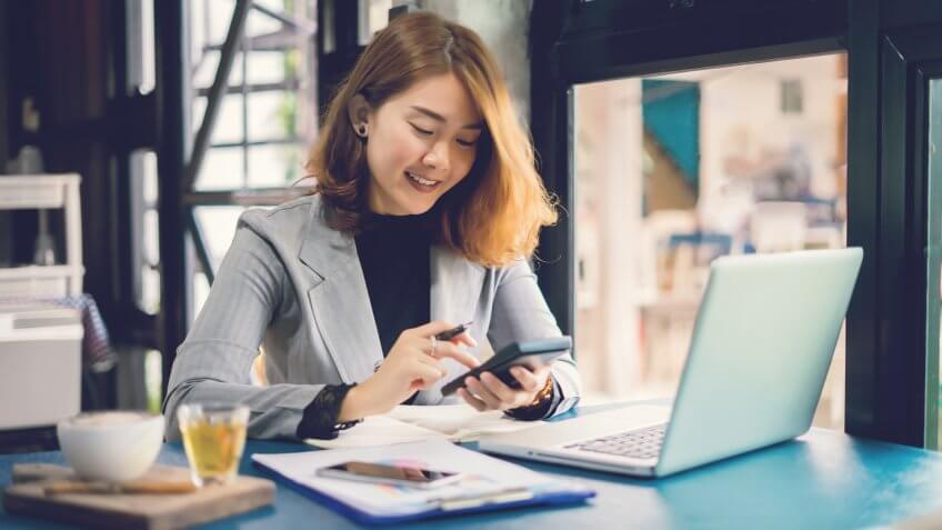 Business woman working with calculator, business document and laptop computer notebook